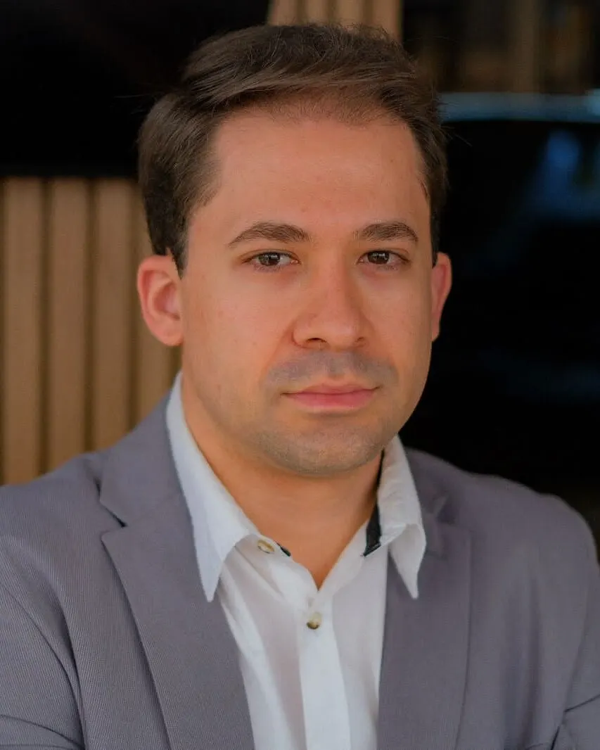 Retrato do Dr. Richard Brasil, de blazer cinza e camisa branca