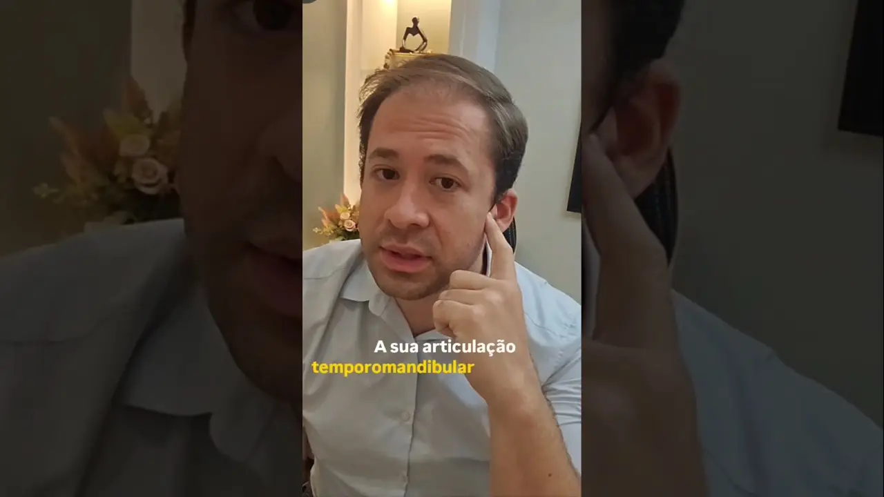 Dr. Richard Brasil aponta para a articulação temporomandibular ao explicar o estalo na ATM